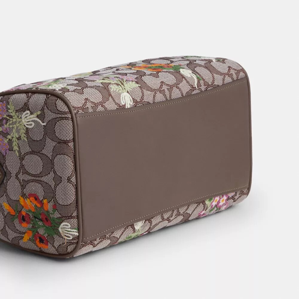 Rowan-skolväska i signaturjacquard med blommig broderi